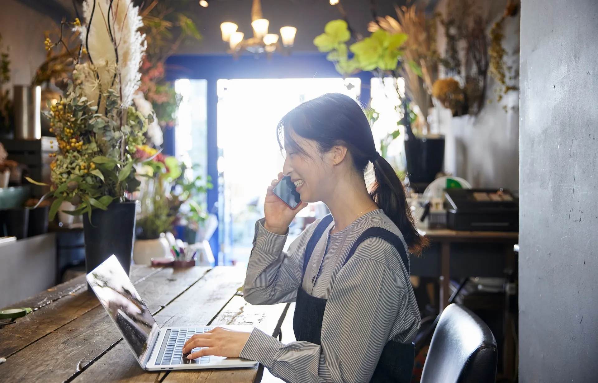 PCで作業をしながら通話している女性店長